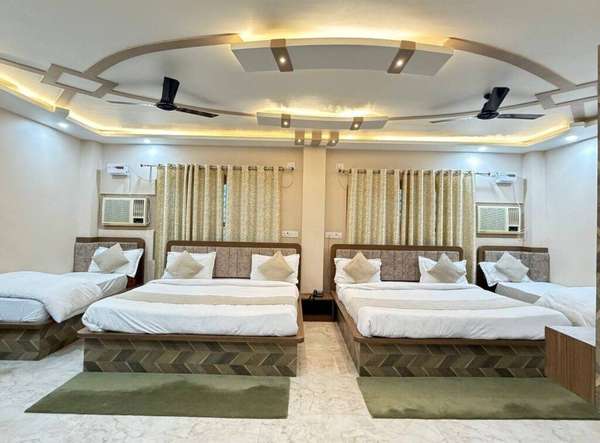 Spacious family hotel room with four beds, modern interiors, LED ceiling lighting, air conditioning, and elegant furnishings